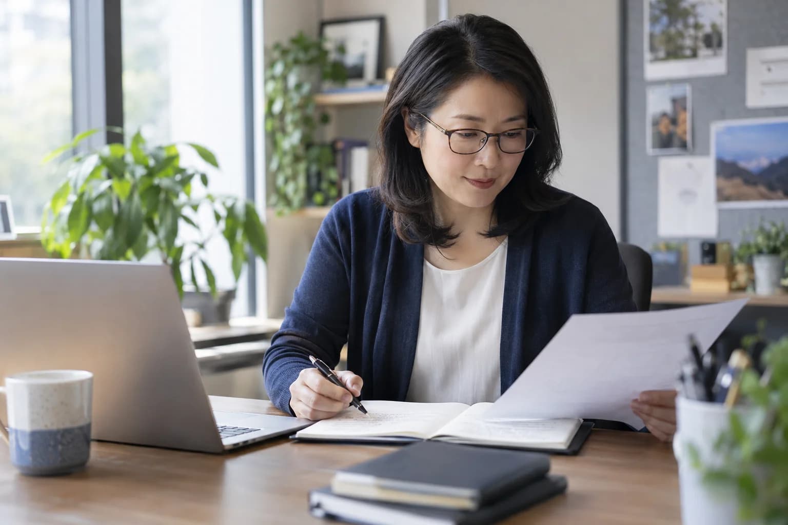 A sales researcher reviewing prospect notes beside a laptop